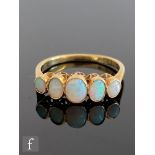 An 18ct opal graduated five stone ring, collar set stones to knife edged shoulders, weight 2.6g,