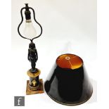 A French Empire style bronzed table lamp and shade, modelled as a Egyptian female standing on a