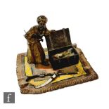 A Bergmann style bronze figure of a man opening a chest of daggers on a carpet, width 12cm.