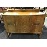 A 1930s light oak sideboard, the ledge back over an angled front and central three drawers