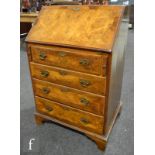 An early 20th Century cross-banded walnut veneered fall front bureau in the George III style, with a