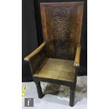 A 19th Century and later carved panelled oak lambing style high back chair on turned legs to the