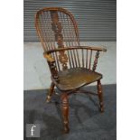 A 19th century yew wood and elm Windsor elbow chair, pierced vase splat on splayed legs united by