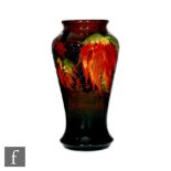 A William Moorcroft Flambe Leaf and Blackberry pattern vase of tapering form, decorated with