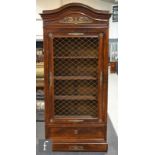 A late 19th to early 20th Century armoire in the French Empire style, with brass lattice panel