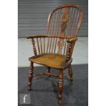 A 19th century yew wood and elm Windsor elbow chair, pierced splat on turned legs united by a