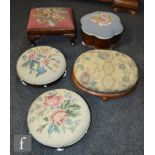 A pair of Victorian mahogany circular footstools upholstered in floral tapestry, on white ceramic