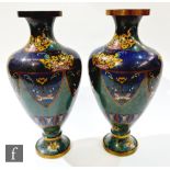 A pair of 20th century Japanese cloisonné brass vases decorated with panels of dragons on a
