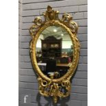 A 19th Century gilt framed girandole wall mirror of oval form, with an acanthus pediment over