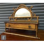 An Arts and Crafts wall hanging mirror bracket with a bobbin turned frieze above a glove box and