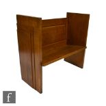 An Art Deco oak church pew or window seat with stepped panel sides and prayer book ledge to the