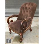 A Victorian easy chair with exposed mahogany frame, scroll arms and turned front legs with applied