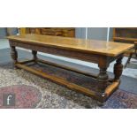 An 18th Century and later large carved oak refectory dining table, the cleated plank top over a