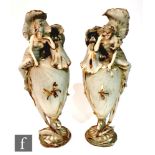 A mirrored pair of early 20th Century Amphora vases in the Art Nouveau style each decorated with a