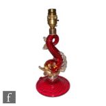 A post war Italian Murano glass table lamp in the form of a stylised dolphin in ruby with applied
