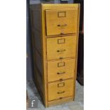 A 1930s oak four drawer filing cabinet mounted with brass handles and card frames, panelled sides,