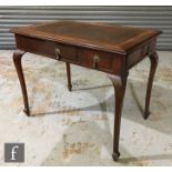 An early 20th Century walnut writing table with inset leather top, fitted with a drawer and a