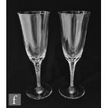 A pair of Lalique Phalsbourg champagne flutes, each with round funnel bowl above a hexagonal faceted
