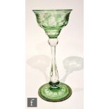 An early 20th Century oversized wine glass, the double ogee bowl cased in green over clear and cut