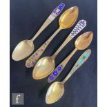 Five Russian silver gilt spoons each with enamel decoration to the handles to include stylised