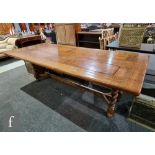 A large oak refectory style dining table, the cleated panelled top on an associated barley twist