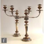 A pair of silver plated on copper twin light candelabra, circular bases below plain flaring column