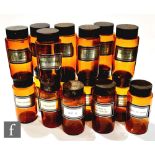 A collection of seventeen mid 20th century amber glass pharmaceutical jars, each with a tin cover