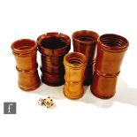 A 19th century boxwood castellated dice shaker and four similar graduated plain examples with single
