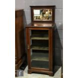 An Edwardian mahogany floorstanding display cabinet of narrow proportions, the bevelled mirror