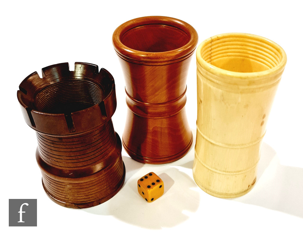 A 19th century castellated turned boxwood dice shaker, a similar shaker of waisted form and an ivory