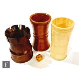 A 19th century castellated turned boxwood dice shaker, a similar shaker of waisted form and an ivory