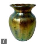 A later 20th Century studio glass vase of fluted ovoid form with an everted rim decorated with green