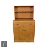 A Heals Arts and Crafts Cotswold School style oak dresser of small proportions, the upright