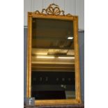 A gilt and gesso pier mirror with tied ribbon pediment and with rosette capitals to the corners,