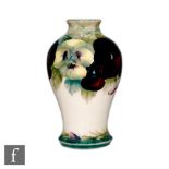 A William Moorcroft Pansy on White pattern vase of baluster form, decorated with tubelined flower