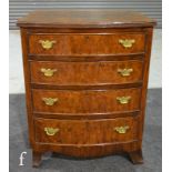A George III style crossbanded walnut bow front chest of four long drawers, on splayed bracket feet,