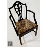 An early 20th Century Hepplewhite style ebonised mahogany elbow chair with pieced feather splat