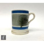 A 19th Century Mocha ware straight sided mug decorated with blown tree silhouettes, height 9.5cm.