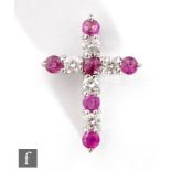 An 18ct white gold ruby and diamond cross comprising eleven alternating claw set stones, length 2.