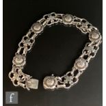 A Danish silver bracelet with alternating floral and pierced panels united by oval jump rings and