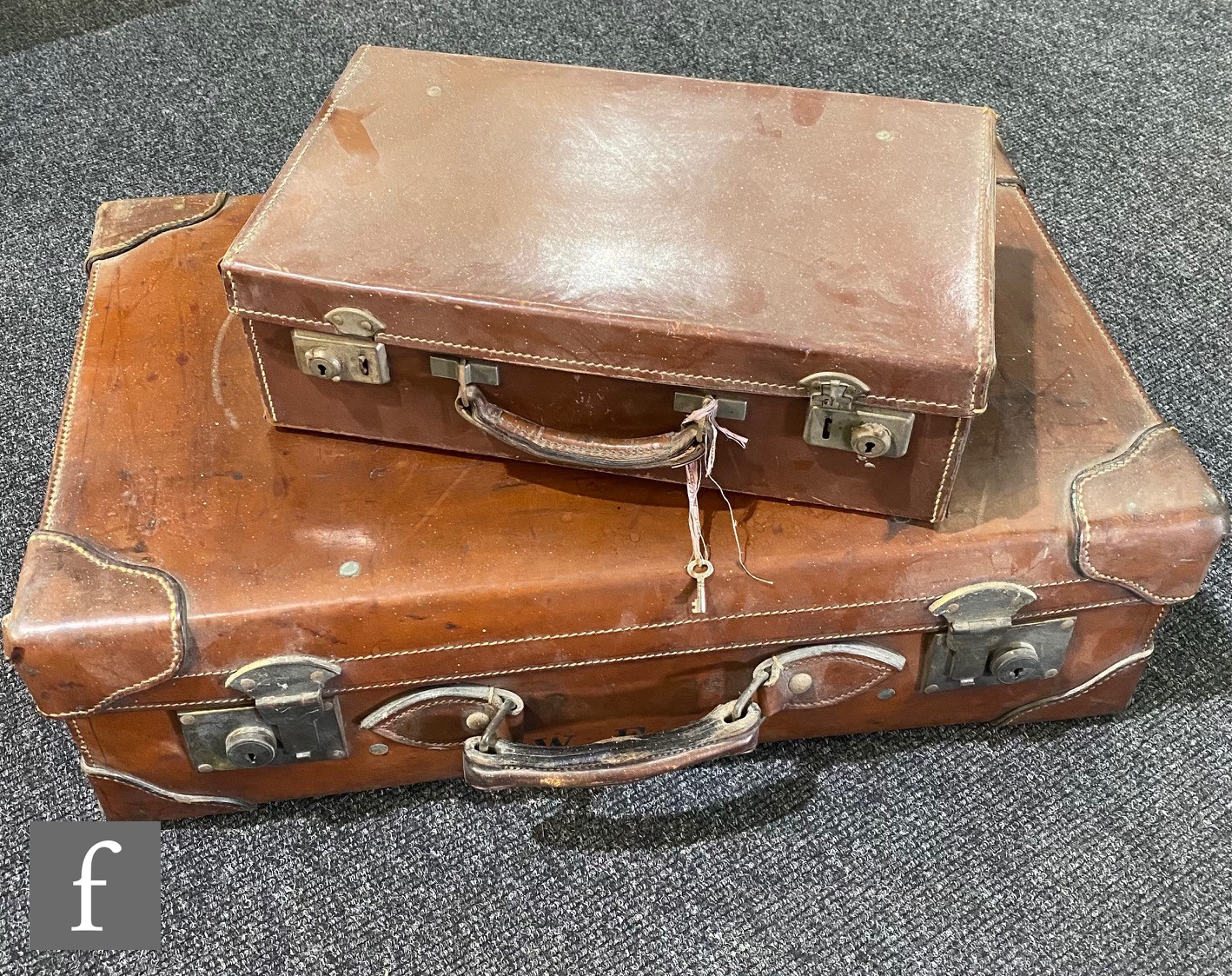 An early 20th Century leather suitcase with a lined interior, stamped with the monogram W.E.P, width