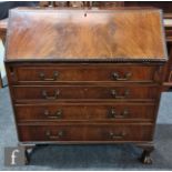 An Edwardian Chippendale style mahogany bureau, the fitted interior over four long drawers, on