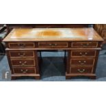 An Edwardian style crossbanded kneehole desk of narrow proportions, the leather inset top over three