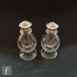 A pair of 19th Century ecclesiastical clear crystal glass bottles of footed ovoid form with white