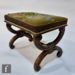 A Victorian rosewood stool on scroll cross frame, upholstered in floral tapestry on a green
