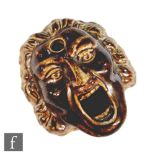 A 19th Century salt glazed pen stand modelled as a screaming man with a foliate garland in his hair,