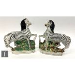 A pair of 20th Century Staffordshire models of zebras each on a naturalistic base, height 21.5cm.