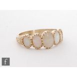 A 9ct hallmarked opal five stone ring, graduated claw set stones to scroll detailed shoulders,