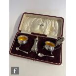A 1920s three piece silver cruet, the open salt and mustard pots with yellow enamelled interiors,