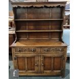 A 17th century style oak dresser, the three tier rack over lunette carved drawers and cupboard base,